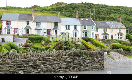 Una fila di vecchie case a schiera con grazioso e ben tenuti giardini frontali, vicino al mare in Mortehoe, Devon, Inghilterra, Regno Unito. Foto Stock