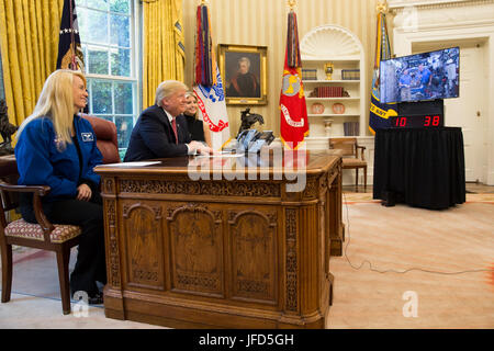 Presidente Donald Trump parla tramite video conferenza con gli astronauti della NASA il comandante Peggy Whitson e Jack Fischer a bordo della Stazione Spaziale Internazionale, nell'ufficio ovale di lunedì, 24 aprile 2017. Presidente Trump, insieme con la signora Ivanka Trump e l'astronauta della NASA Kate Rubins, chiamato a congratularmi con il comandante Whitson per rompere il record per la maggior parte del tempo nello spazio di ogni astronauta americano, e lodare la relatrice per il lavoro svolto nella promozione delle donne nei campi dello stelo. (Gazzetta White House foto da Benjamin Applebaum) Foto Stock