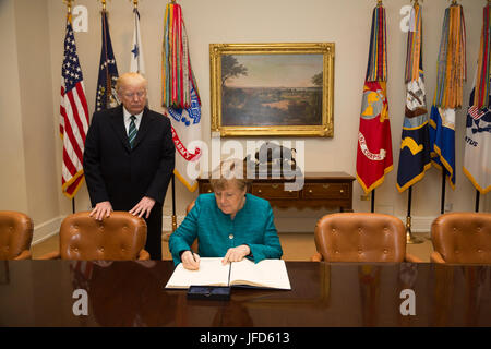 Il presidente Donald Trump accompagna la cancelliera tedesca Angela Merkel mentre firma il libro degli ospiti, venerdì 17 marzo 2017, nella stanza di Roosevelt, durante la sua visita ufficiale alla Casa Bianca a Washington, D.C. Foto Stock