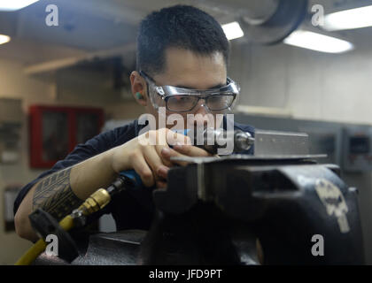 Acque di Guam (27 giugno 2017) DEGLI STATI UNITI Aviazione Navale meccanico strutturale Airman Timothy Songao, nativo di Las Vegas, crea una staffa di metallo a bordo della portaerei USS Nimitz CVN (68), 27 giugno 2017, nell'Oceano Pacifico. Nimitz è attualmente su un periodo in corso nel 7 ° flotta area di operazioni. Gli Stati Uniti Marina ha pattugliato il Pacifico Indo-Asia di routine per più di 70 anni regionale di promozione della pace e della sicurezza. (U.S. Foto di Marina di Massa lo specialista di comunicazione di terza classe Ian Kinkead) Foto Stock