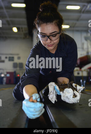 Acque di Guam (27 giugno 2017) DEGLI STATI UNITI Navy Fireman Rachel Garcia, nativo di Albuquerque, N.M., pulisce blast porta le tracce nella baia di hangar della portaerei USS Nimitz CVN (68), 27 giugno 2017, nell'Oceano Pacifico. Nimitz è attualmente su un periodo in corso nel 7 ° flotta area di operazioni. Gli Stati Uniti Marina ha pattugliato il Indo-Asia-Pacifico di routine per più di 70 anni regionale di promozione della pace e della sicurezza. (U.S. Foto di Marina di Massa lo specialista di comunicazione di terza classe Leon Wong) Foto Stock