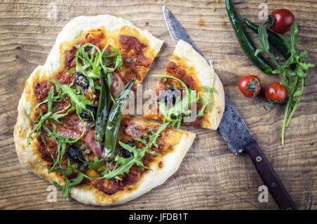 Pizza Salame su una vecchia tavola di legno Foto Stock