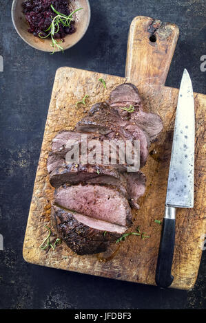 Arrosto di carne di cervo affettare sul bordo di taglio Foto Stock