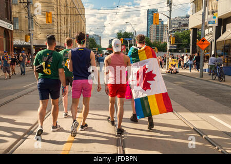 Toronto, CA - 25 Giugno 2017: vista posteriore di un gruppo di cinque giovani uomini a camminare sulla strada della Chiesa dopo il Pride Parade. Foto Stock