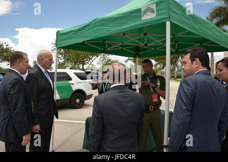 Al porto marittimo di Newark, New Jersey, un ufficiale del CBP monitora le operazioni quando un container marittimo viene caricato su un camion per il trasporto. Ciò garantisce ispezioni e conformità alle normative doganali statunitensi durante le operazioni portuali. Foto Stock