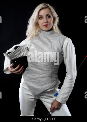 Ritratto di donna adulta fencer tenendo corsi di formazione e la maschera di rapier. Sport olimpici, le arti marziali e la formazione professionale di concetto Foto Stock