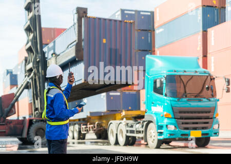 Il caporeparto di caricamento di controllo casella di contenitori da trasporto merce nave per la logistica import export sfondo. Foto Stock