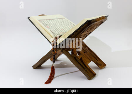 Corano sul cavalletto di legno su sfondo bianco Foto Stock