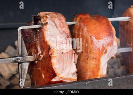 Arrosto di maiale knuckles allo spiedo per una grande azienda Foto Stock