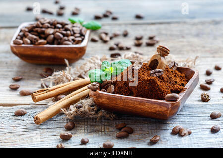 Il caffè macinato in una ciotola di legno e bastoncini di Cannella di Ceylon. Foto Stock