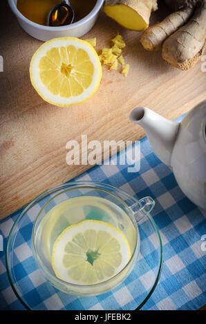 Cucina verticale scena di preparazione contenenti ingredienti per un miele, limone e zenzero drink - una casa a base di erbe Remedy per il freddo e la stagione influenzale. Foto Stock