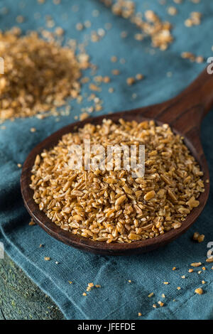 Materie organica marrone Bulgar di frumento in un cucchiaio Foto Stock