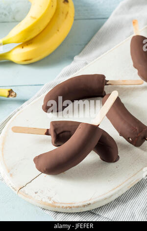 In casa congelati ricoperta di cioccolato banane su un bastone Foto Stock