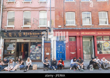 Inghilterra, Londra, Tower Hamlets, Brick Lane, Brick Lane market, persone mangiare cibo da asporto Foto Stock