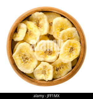 Banane essiccate chip nella ciotola di legno. Giallo fritti fette di banane, ricoperti di zucchero o miele. Merenda con gusto dolce. Isolate il cibo macro foto Foto Stock