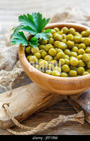 Sweet conserve di piselli verdi in una ciotola di legno. Foto Stock