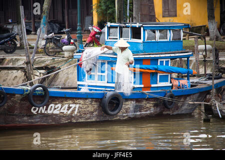 Pescatore sulla sua barca sul fiume Thu Bon in Hoi An, Vietnam Foto Stock