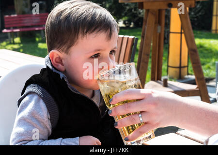 Bambino beve acqua da un bicchiere Foto stock - Alamy