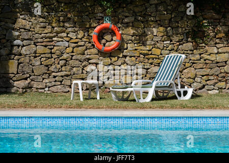 Lettino accanto a una piscina all'aperto Foto Stock