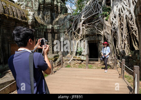 I turisti a scattare foto al Ta Prohm tempio, Siem Reap provincia, Cambogia Foto Stock