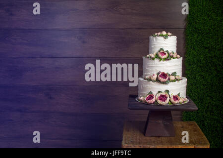 Bella tiered torta di compleanno sul legno scuro dello sfondo. Foto Stock