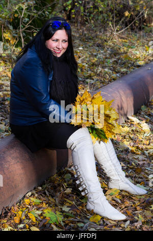 Autunno ragazza giocare nel parco della città. Foto Stock