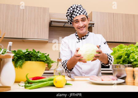 Il giovane chef lavorando in cucina Foto Stock