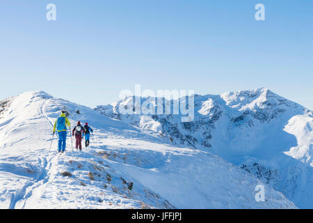 Vista posteriore di sciatori salendo sulla montagna di neve Foto Stock