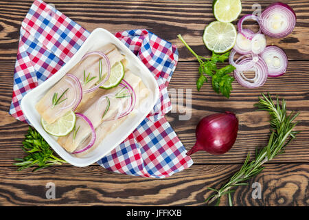 Tagliate a fette i filetti di aringhe, tagliare la cipolla e calce Foto Stock