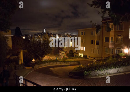 Una vista della Coit Tower e il Ponte della Baia di San Francisco, da Lombard Street, il più crooked street nel centro cittadino di San Francisco. Foto Stock