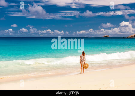 Donna con sarong sulla spiaggia a Seychelles Foto Stock