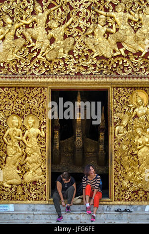 Due turisti di mettere le scarpe dopo aver immesso il Wat Xieng Thong tempio buddista a Luang Prabang, Laos, Asia Foto Stock