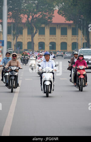 Persone a cavallo scooters sulle strade di Hanoi, Vietnam Asia Foto Stock