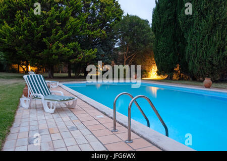 Sedia a sdraio accanto alla piscina all'aperto Foto Stock