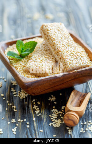 Barre con i semi di sesamo in una ciotola di legno. Foto Stock