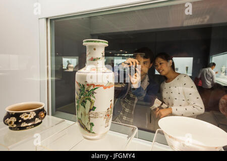 Cina, Shanghai, il Museo di Shanghai, giovane guardando antichi Display in ceramica Foto Stock