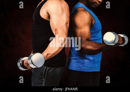 Immagine composita di forti amici in posa con manubri Foto Stock