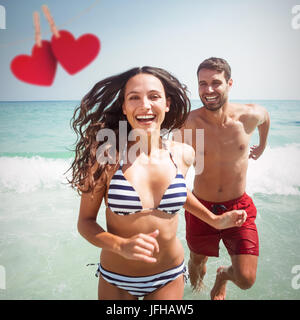 Immagine composita della coppia felice in esecuzione fuori acqua Foto Stock