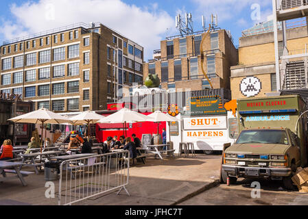 Pop up ristoranti esterni con persone mangiare outiside presso la Old Truman Brewery, Ely's Yard, Shoreditch, London, Regno Unito Foto Stock