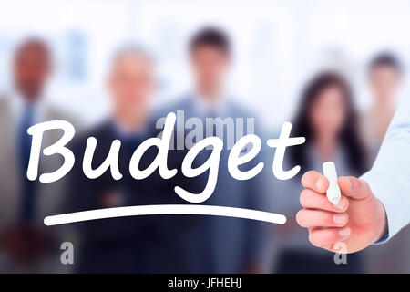 Imprenditore in camicia la scrittura con un marcatore contro le forme gravi di business team guardando la telecamera mentre in piedi di fronte a una finestra Foto Stock