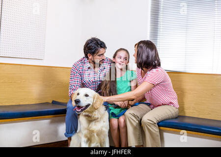 In attesa di famiglia sulla IFP sala di attesa con il loro cane Foto Stock