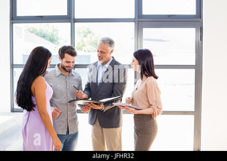 Real Estate Agent consegna accordo carta per paio Foto Stock