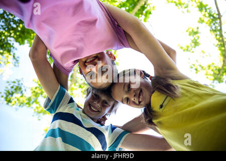 Ritratto di bambini felici formando un huddle in posizione di parcheggio Foto Stock