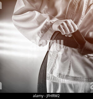 Immagine composita del fighter di serraggio della cinghia di karate Foto Stock