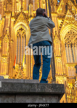 Un fotografo spara le guglie della cupola a Colonia, Koln Dom, Colonia, Germania nel sole del pomeriggio Foto Stock