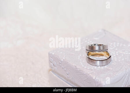 Gli anelli di nozze in oro e platino con diamanti su bianco preziosi gioielli box Foto Stock