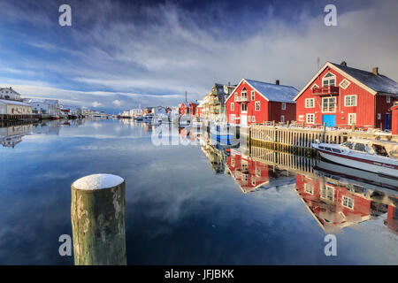 Case Rosse si riflette nel canale di Henningsvaer, Isole Lofoten in Norvegia, Europa Foto Stock