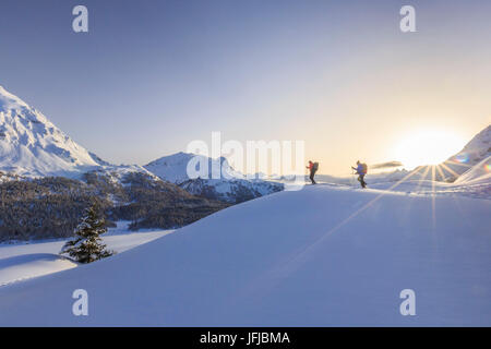 Escursioni con le racchette da neve avventura nella neve profonda dopo una nevicata oltre i laghi ghiacciati di Engadina, nel Canton Grigioni, Maloja Pass, Engadina, Svizzera, Europa Foto Stock