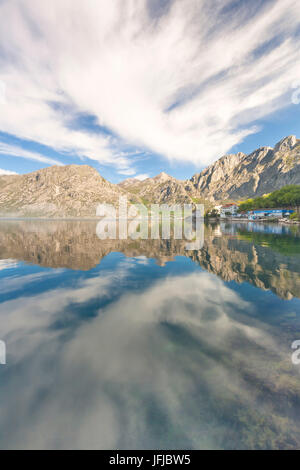 Nella Baia di Kotor il mare è circondato da montagne che si riflettono nelle acque calme al mattino, nell'angolo dell'immagine del villaggio di Ljuta, Montenegro Foto Stock