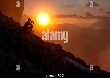 Fotografo medita di fronte al tramonto sul Cadini di Misurina, Dolomiti, Veneto, Italia Europa Foto Stock